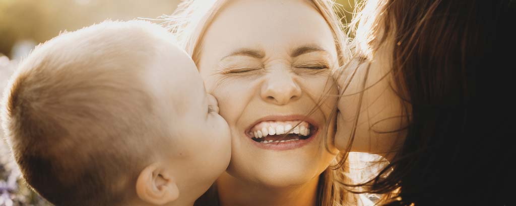 a woman gets kisses from her children after they go through vital pulp therapy